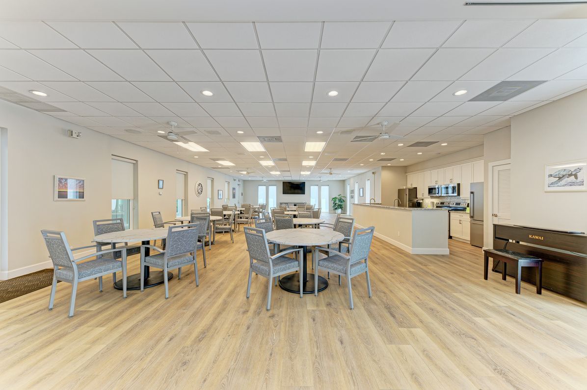 Remodeled clubhouse with dining tables, kitchen and piano