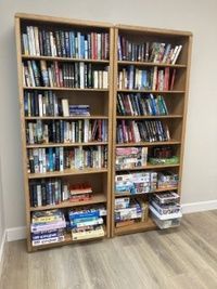 Community library bookshelves with books and games